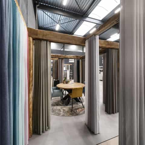 Liveleff showroom met gordijnen en daklicht Doorkijk door een showroom met gordijnen aan weerszijden en lichtinval van boven