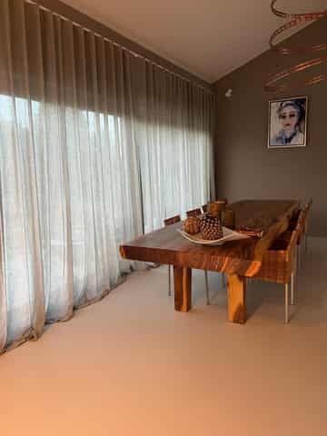 Liveleff sfeerbeeld met gordijnen in een eethoek Gordijnen over een brede raamzijde, met zitmeubelen en een tafel
