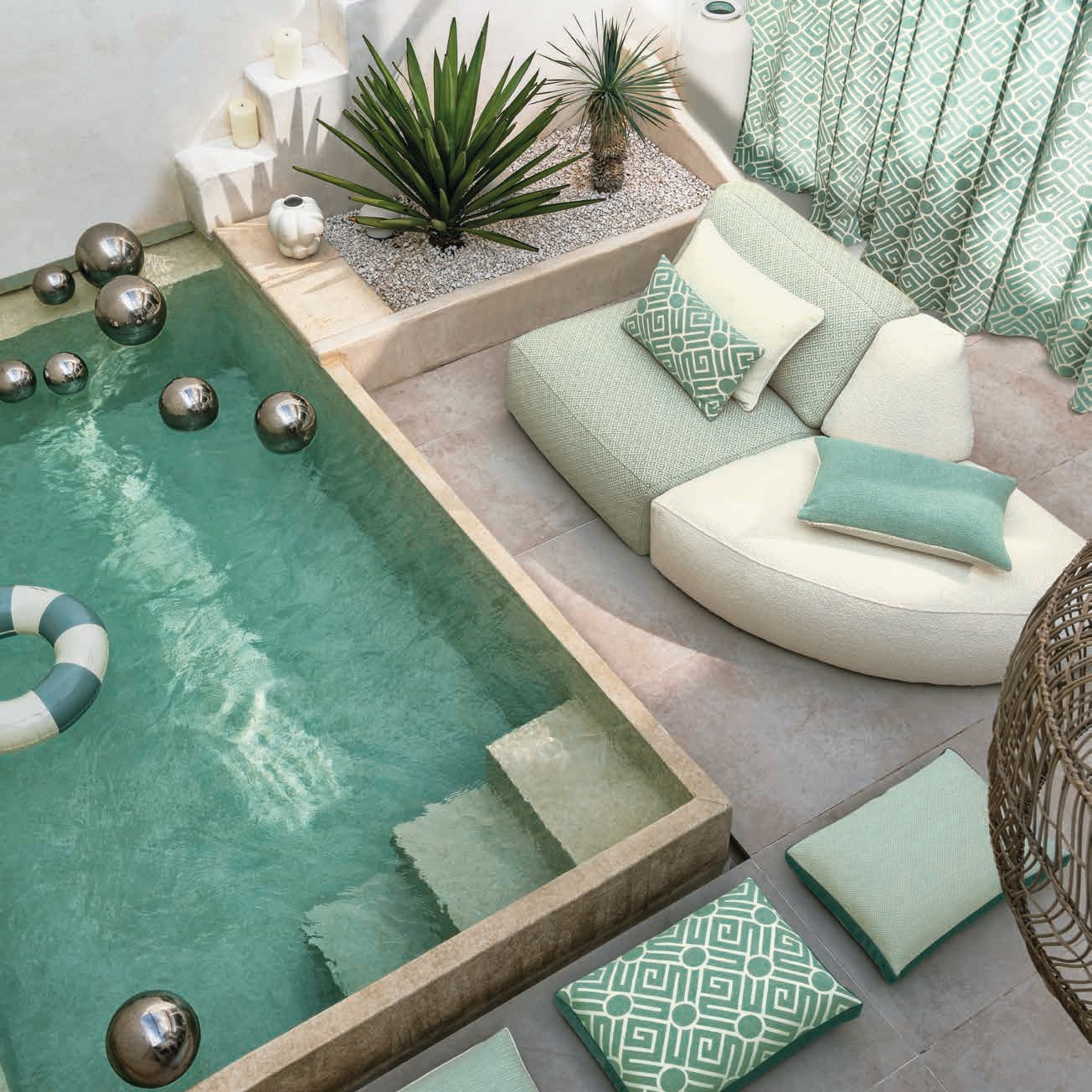 Buiteninterieur met maatkussens en beklede lounge-elementen in mintgroene meubelstoffen.