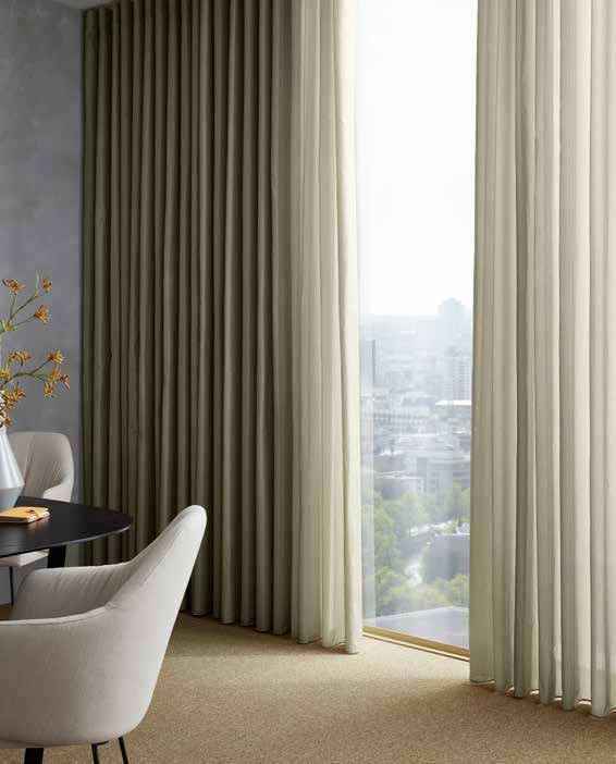JAB akoestische gordijnen: Silencer-stoffen uitgelegd 1 JAB SILENT BREEZE akoestische gordijnen bij een hoge raampartij in een modern interieur